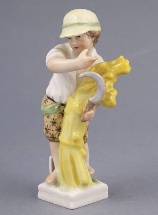 Porcelanowa figurka chłopca z sierpem i snopkiem siana